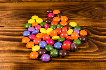 Pile of the multicolored candies on a wooden table