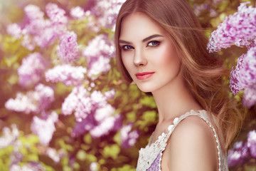 Fototapeta premium Beautiful Woman with Flowers of Lilac. Spring Blossom. Sexy Glamour Summer Beautiful Lady with Healthy and Beauty Hair