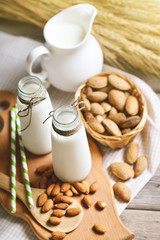 Almond and almond milk on a wooden table in the summer garden. Useful food.