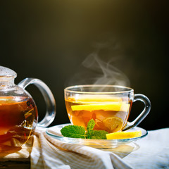 Cup of freshly brewed black tea,warm soft light, darker background.