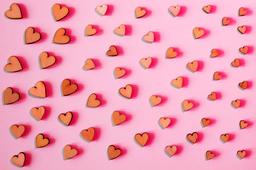 A pattern of hearts of different sizes on a pink background.