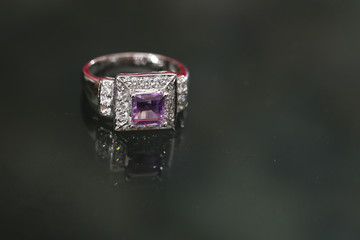 Purple gemstone on diamond ring