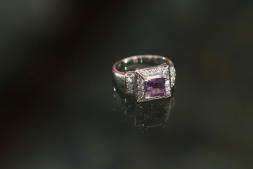 Purple gemstone on diamond ring