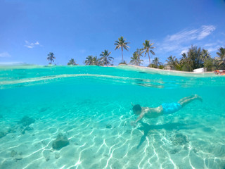 HALF UNDERWATER: Young male tourist swims near the awesome paradise island.