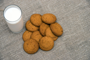 glass of milk and oatmeal cookies on a gray concrete background. Top view