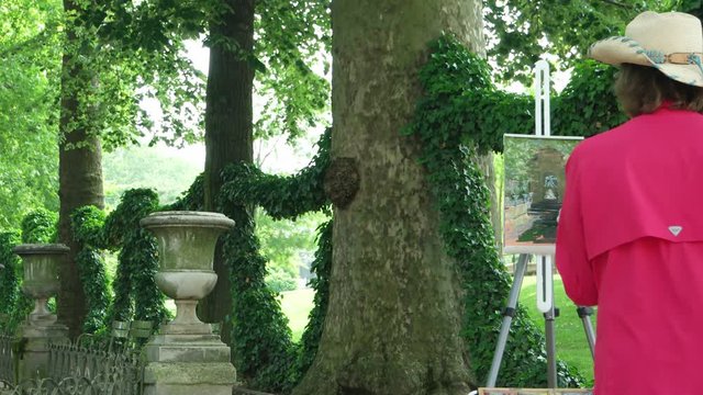 May 23, 2018. Luxembourg Garden,   Paris, France.  The  unknown artist paints outdoors the Medici Fountain in the garden
