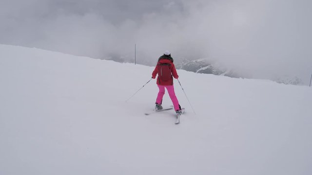 Woman Skier Skiing Down The Mountain Slope In A Heavy Fog