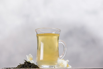 Green tea with jasmine in a glass mug.