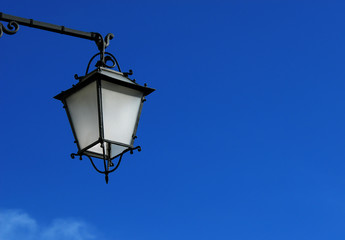 Fototapeta na wymiar Old fashioned street lamp against blue sky (with copy space)
