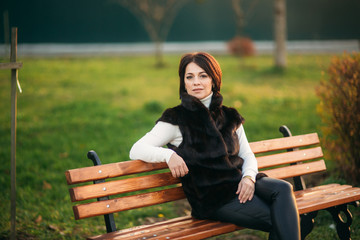 A young mother walks through the park in the golden autumn