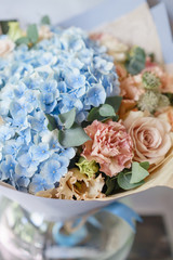 beautiful spring bouquet. flower arrangement with hydrangea. Color light blue. The concept of a flower shop, a small family business