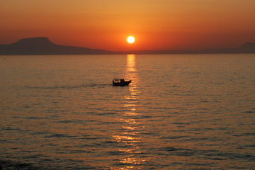 Fishing boat at sunset  - island of Crete.