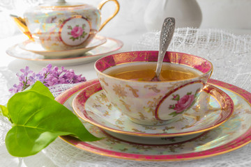 cup of tea on a light table near a window in the morning and bunches of flowers with a copy space