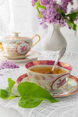 cup of tea on a light table near a window in the morning and bunches of flowers with a copy space