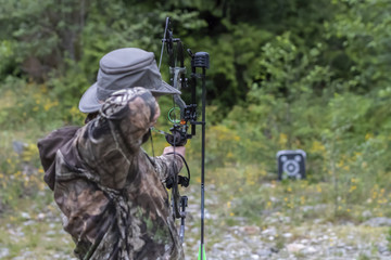 A Man Shooting a Compound Bow at a Target.