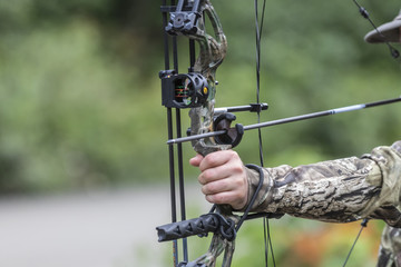 A Compound Bow and arrow drawn close up.