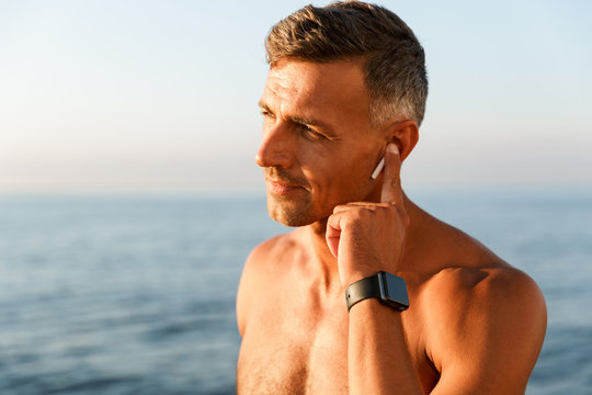 Close up of handsome shirtless sportsman with earphones