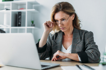 attractive businesswoman working in office with notebook and laptop