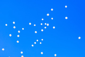 White balls flying in the blue sky