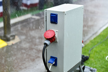 Raindrops are seen on industrial electric plug during heavy rain
