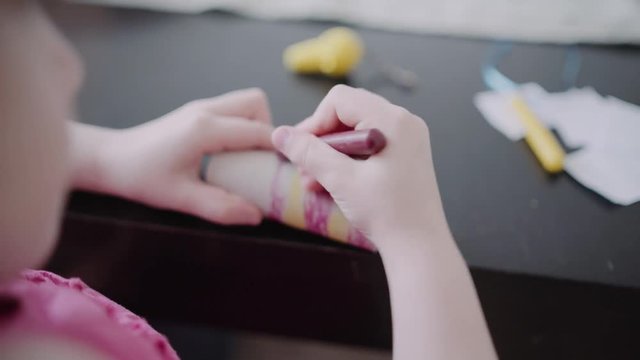 Little girl painting / tinkering on a piece of cardboard