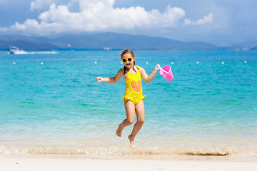 Kids play on tropical beach. Sand and water toy.