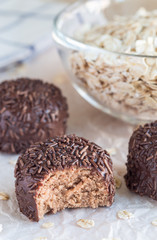 Swedish sweets Arrack balls, made from cookie crumbs, cocoa, butter and coconut wine Arrack flavour, on wooden table, vertical