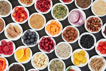 Health food for a healthy heart with vegetables, fruit, grains, pulses, nuts, seeds and medicinal herbs and spice. Super food concept with foods high in antioxidants, omega 3 , smart carbs & vitamins.