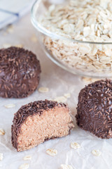 Swedish sweets Arrack balls, made from cookie crumbs, cocoa, butter and coconut wine Arrack flavour, on a wooden table, vertical