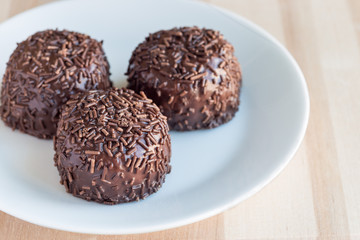 Swedish sweets Arrack balls, made from cookie crumbs, cocoa, butter and coconut wine Arrack flavour, on wooden table, horizontal