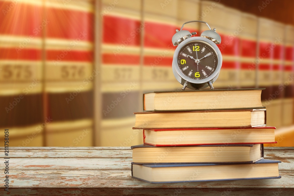 Poster composite image of alarm clock and stack of books