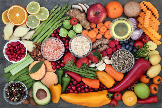 Health food selection with fresh vegetables, fruit, herbs, spices, grains, seeds, himalayan salt and olive oil. Super foods very high in antioxidants and vitamins.