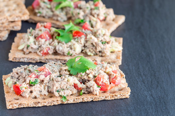 Salad with tuna, avocado, tomatos, coriander and lemon juice, served on crispbread, horizontal,...