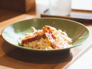 Bacon Spaghetti white sauce served on green dish.