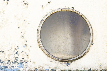 Rusty colourful painted metal texture and round window close up