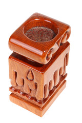 Single old brown wooden candlestick without candle with carved droplets in form of melted wax. Isolated on a white