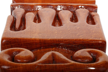 Details of an brown wooden candlestick without candle with carved droplets in form of melted wax. Isolated on a white