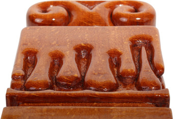 Details of an brown wooden candlestick without candle with carved droplets in form of melted wax. Isolated on a white