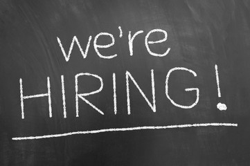 We are hiring announcement chalk text on blackboard or chalkboard.