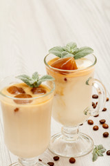Two glasses of delicious milkshake (smoothie) with chocolate ice and leaves of mint