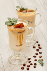 Two glasses of delicious milkshake (smoothie) with chocolate ice and leaves of mint