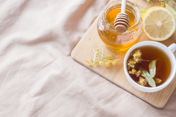 Tea with Linden, honey and Lemon. The tray on the bed, the Concept of the treatment of colds