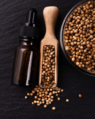 coriander seeds on a dark stone background, essential oil