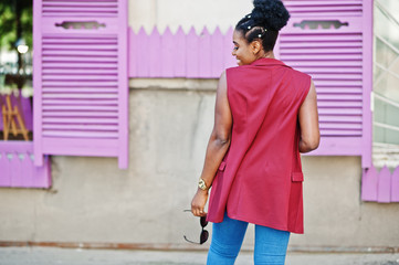 African american girl posed against purple windows outdoor.