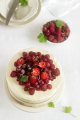 Summer home biscuit cake with curd cream, decorated with fresh berries of strawberries, raspberries and currants.