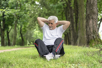 Senior man stretching after jogging in the park