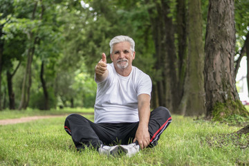 Fototapeta premium Senior man stretching after jogging in the park