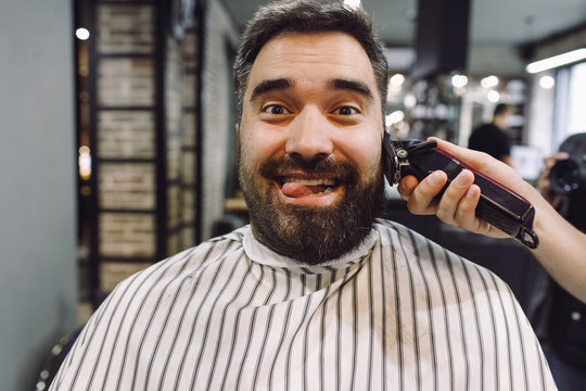 Man looks funny while barber works on him in the barber-shop
