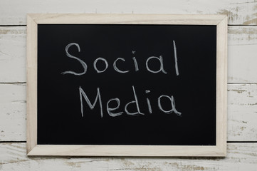 Social Media concept. Blackboard with text "Social Media" on wooden background, top view