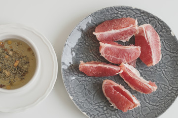 Cup of herbal tea and sliced grapefruit on white background, top view